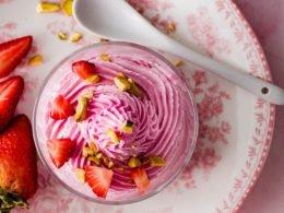 overhead shot of several bowls of strawberry sparkle magic mousse with fresh strawberries and edible glitter