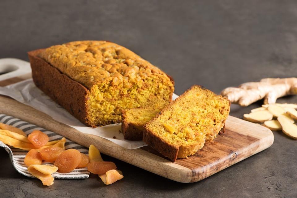 overhead shot of sliced turmeric ginger gluten-free banana bread on a wooden board