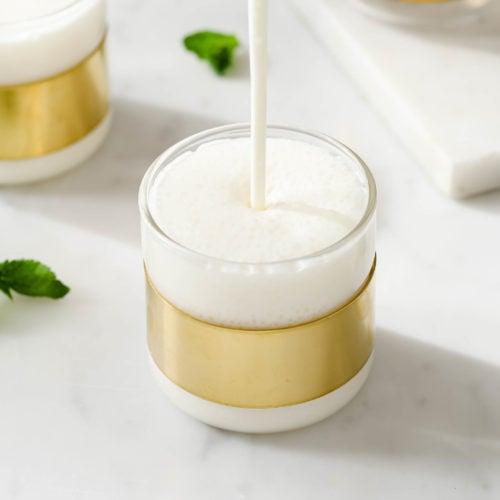 breadfruit vanilla lassi being poured into a glass