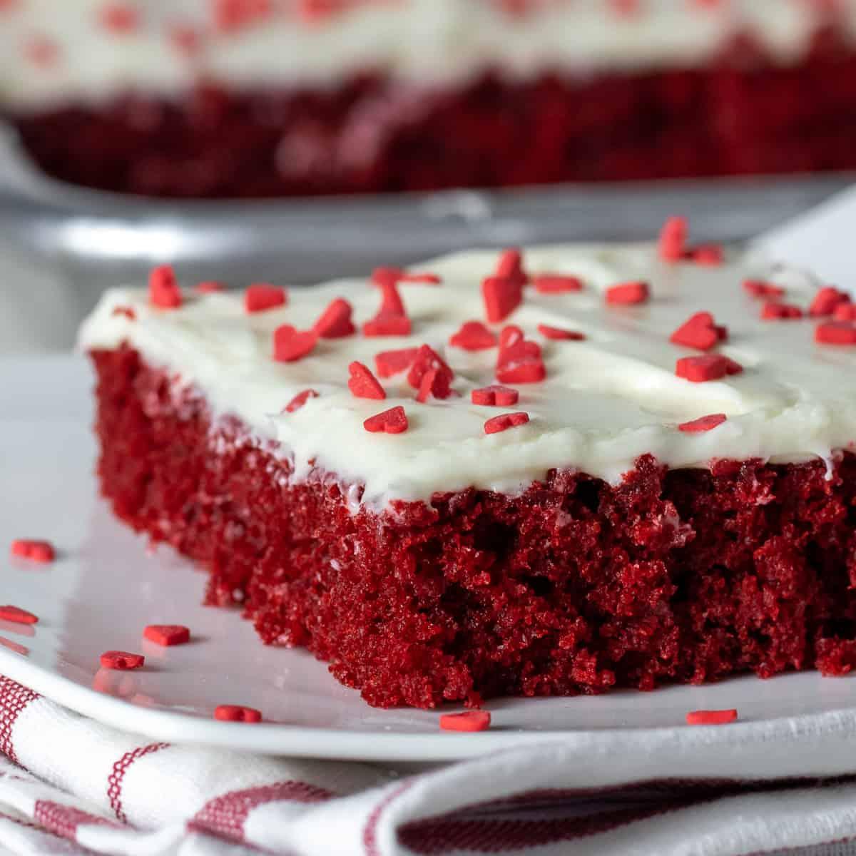 close-up of red velvet cake with cream cheese frosting and sprinkles