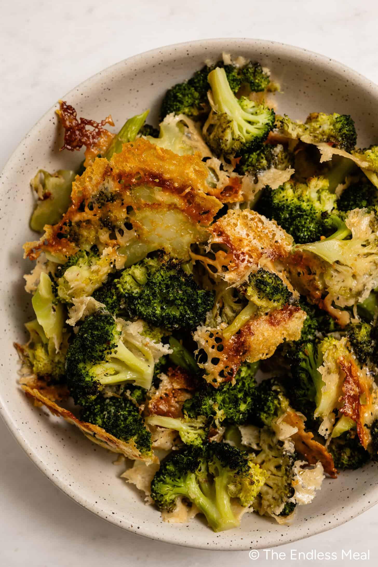 close-up shot of tender-crisp broccoli florets coated with melted Parmesan cheese