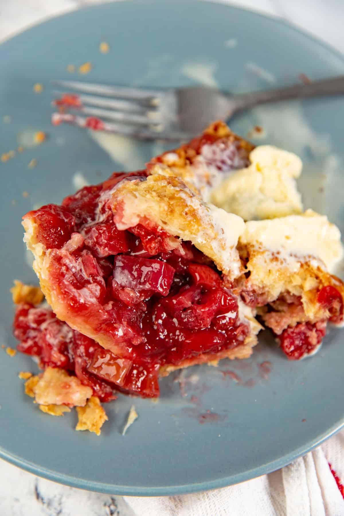 close-up of a slice of grape rhubarb pie with a fork, showcasing the filling