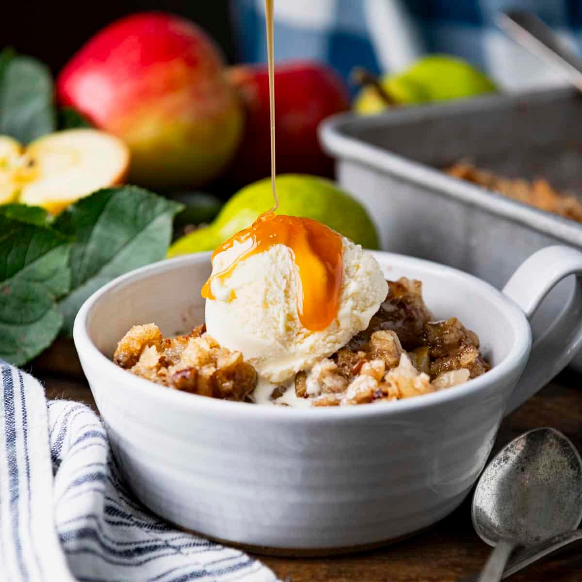close-up shot of a slice of pear crisp being served with vanilla ice cream