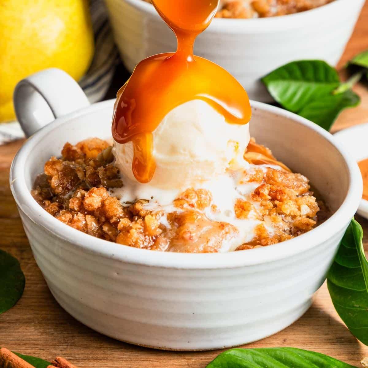 scooping pumpkin spice pear crisp into a bowl