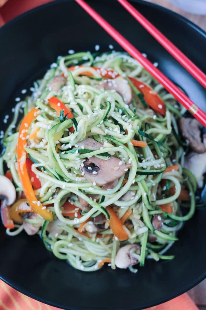 Close-up of a vibrant Mediterranean zoodle stir-fry in a bowl