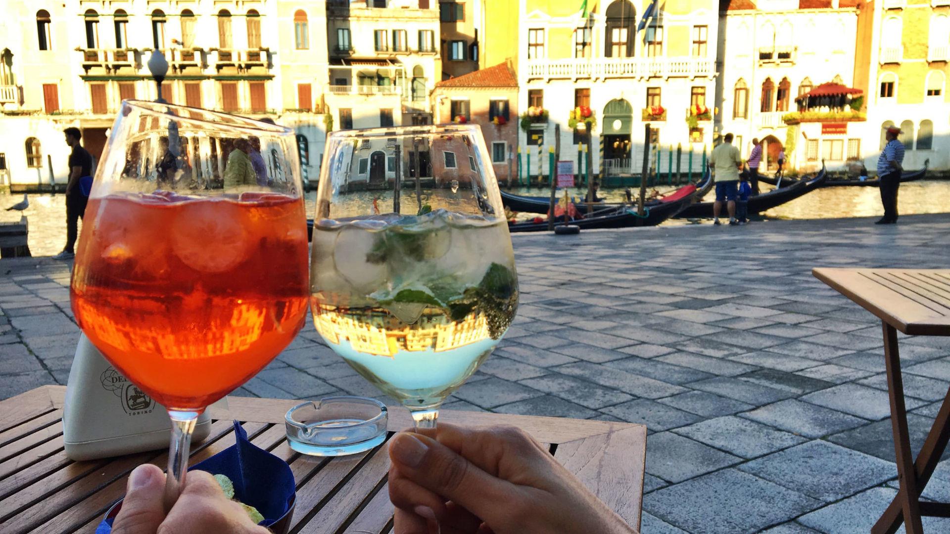 Cafe scene in Venice with a Hugo Spritz on a table