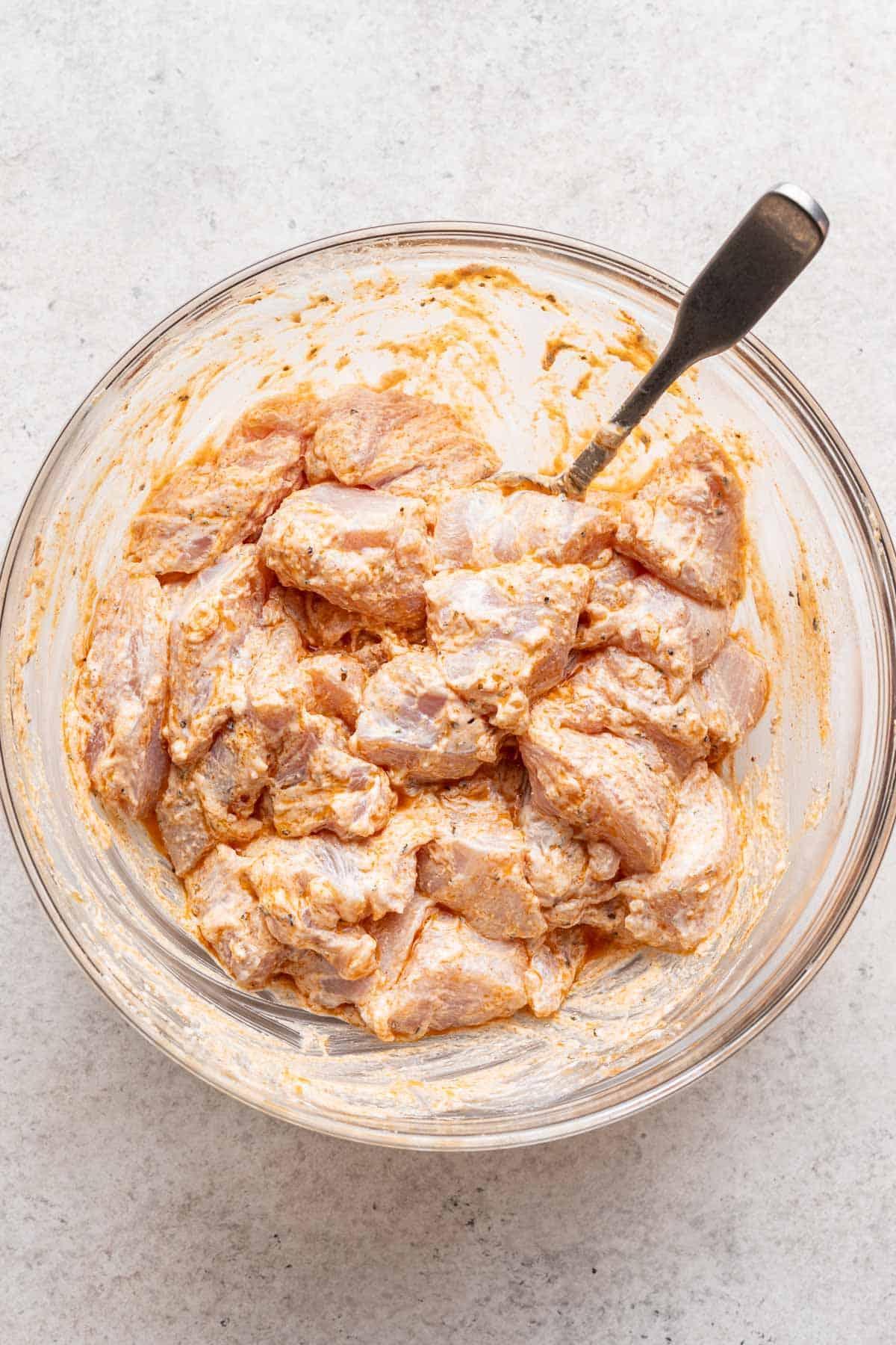 Chicken marinating in a bowl