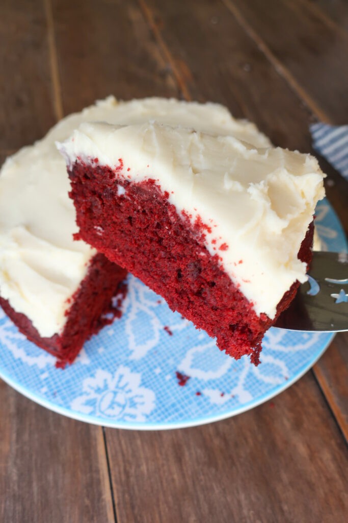 red velvet cake with cream cheese frosting on a white plate