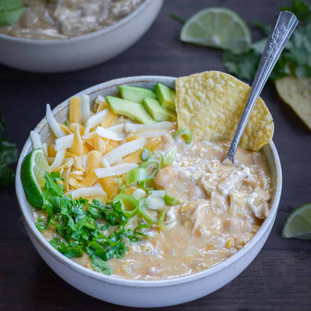 hearty creamy white chicken chili in a rustic bowl with crusty bread on a wooden table, cozy setting