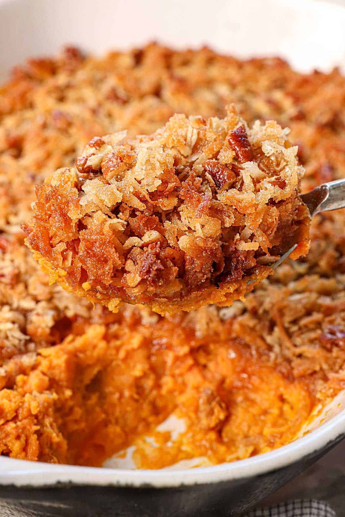 Close-up of golden sweet potato casserole with toasted coconut topping, holiday setting