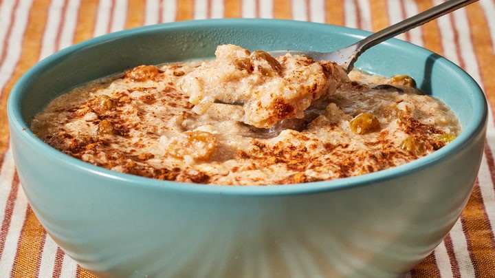 Rustic baked rice pudding with golden crust and a spoonful of creamy goodness, warm and inviting