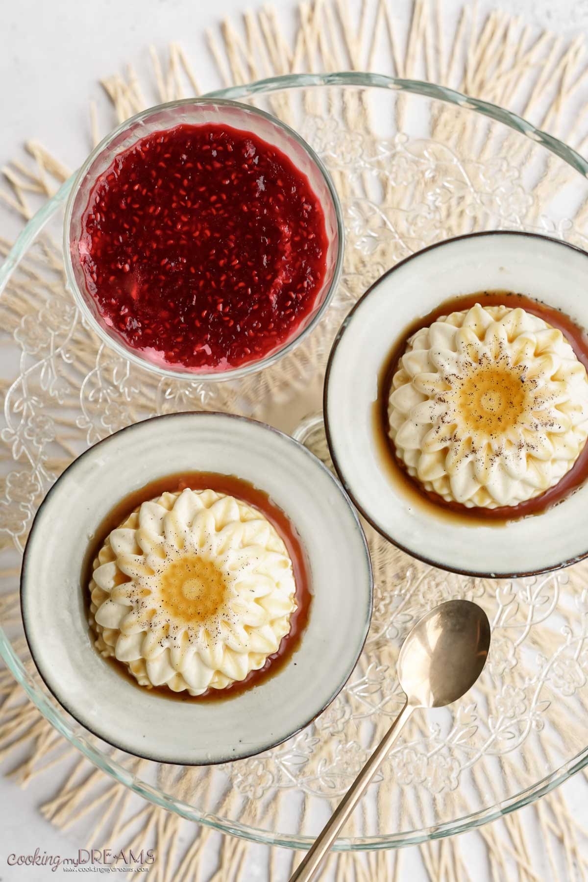 overhead shot of panna cotta served in ramekins with fresh berries and a drizzle of honey