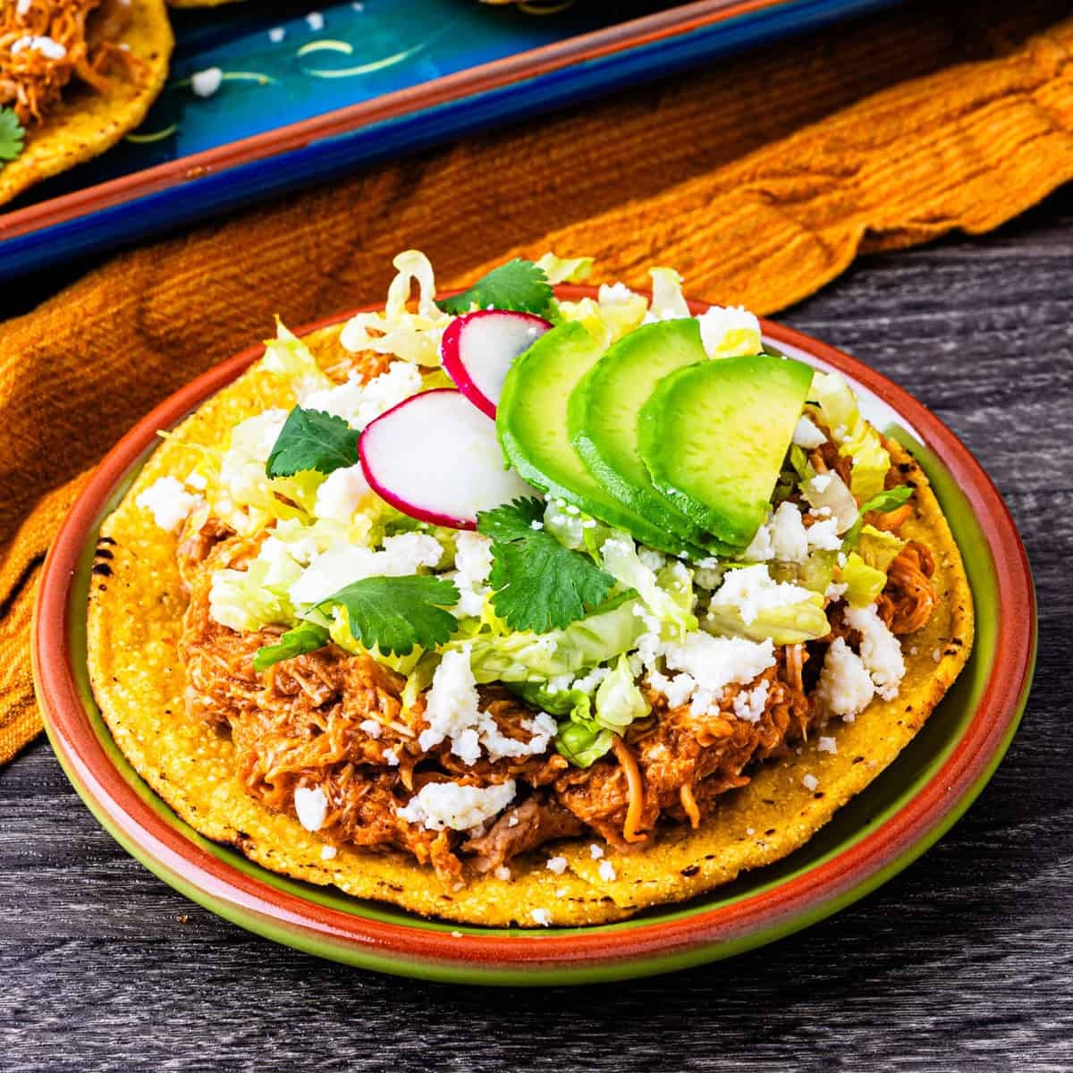 Chicken Tinga Tostadas plated with fresh toppings