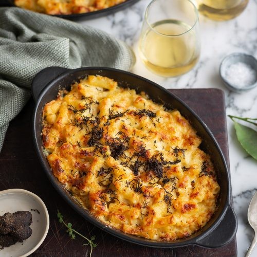 Gourmet truffle mac and cheese with fresh herbs and a rustic background