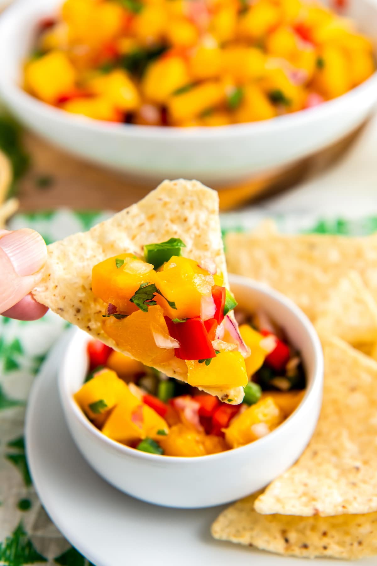 bright and colorful coconut lime mango salsa in a bowl with tortilla chips
