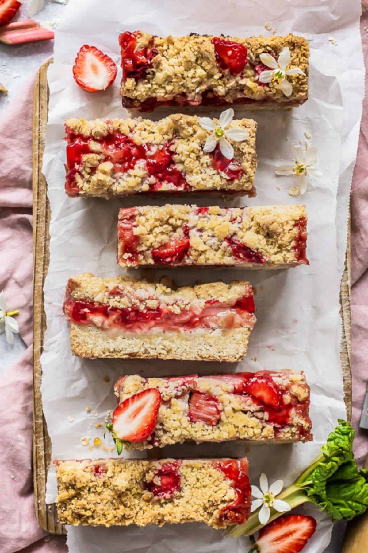 Rhubarb and strawberry shortbread bars on a wooden cutting board