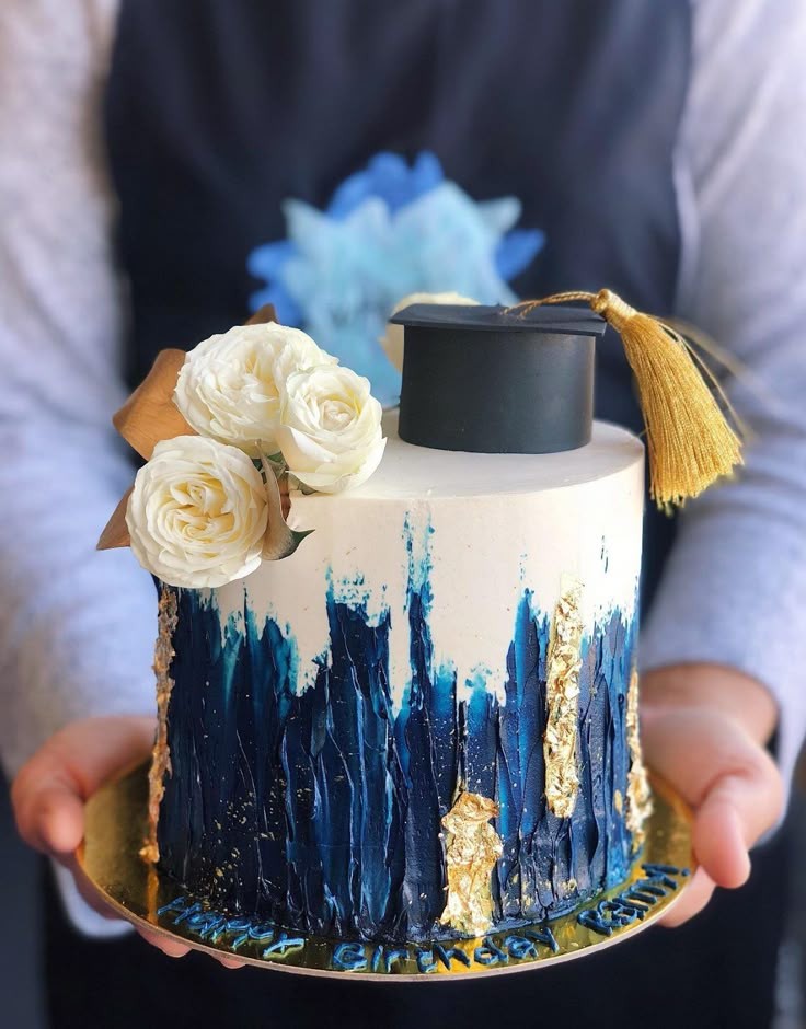 a beautifully decorated graduation cake with blue and gold accents