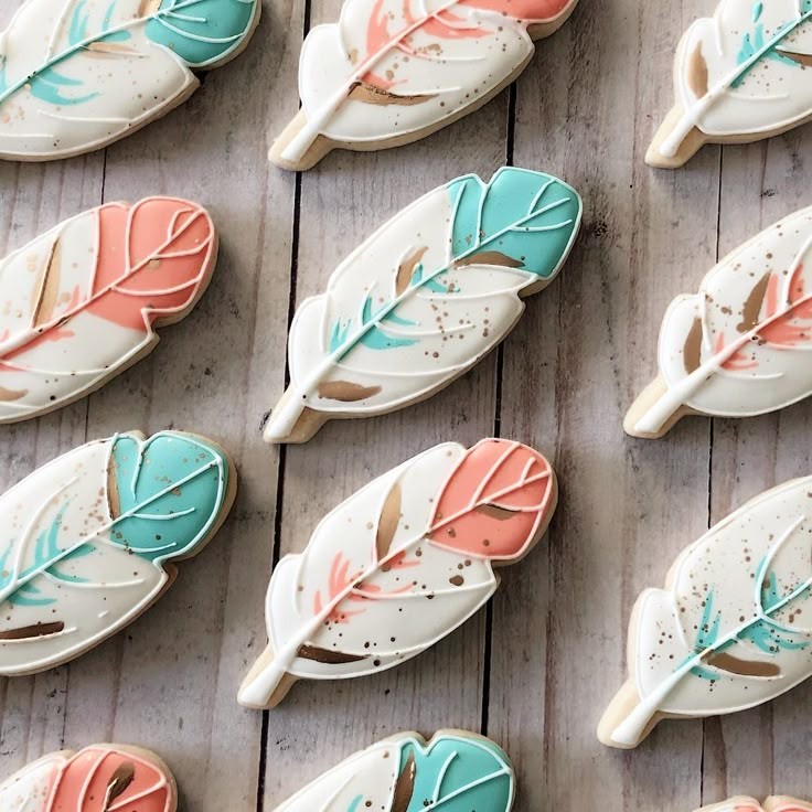 feather-shaped cookies arranged on a rustic wooden table with a cup of tea
