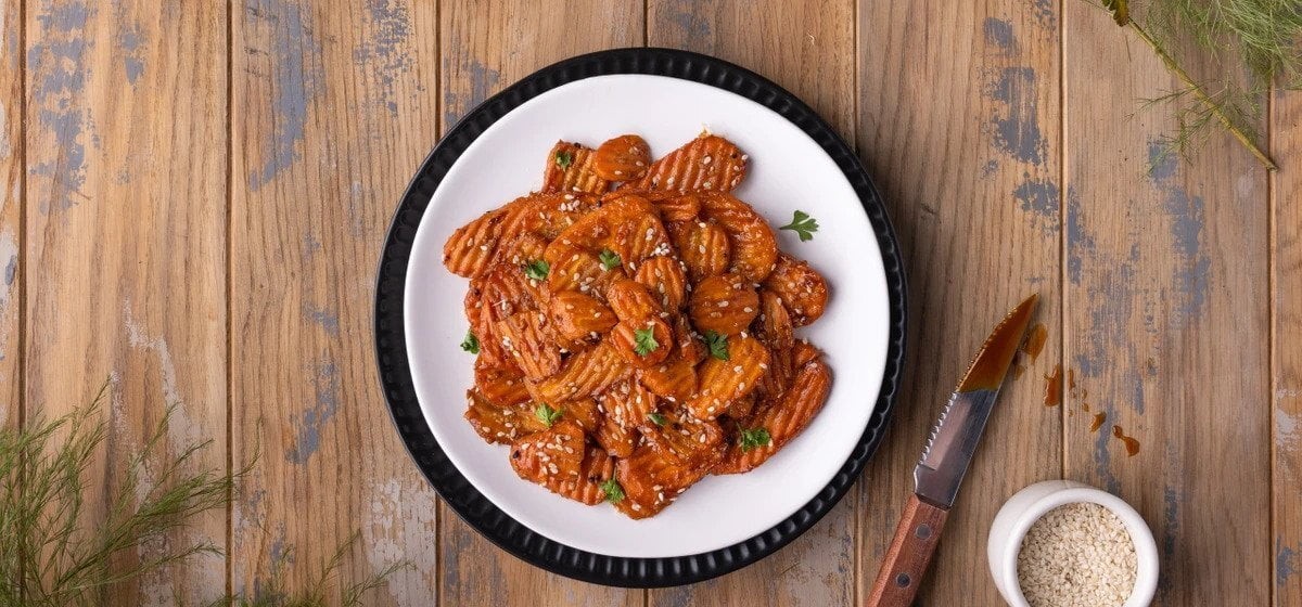 teriyaki glazed carrot fries with green onions on a plate