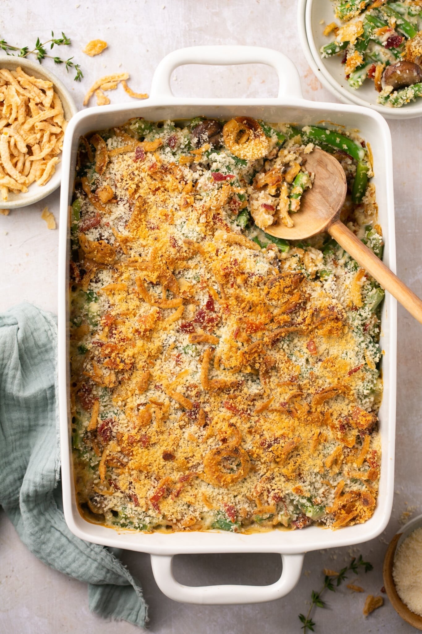 Homemade green bean casserole with golden crispy onion topping, family style, warm lighting