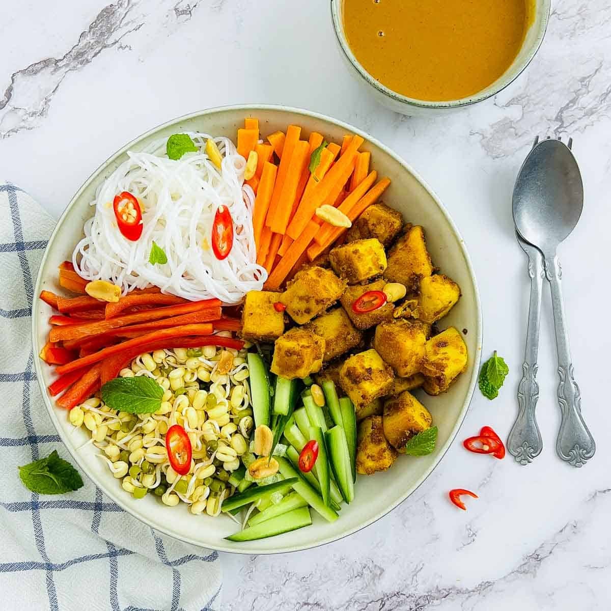 a vibrant tofu and zucchini bowl with colorful garnishes