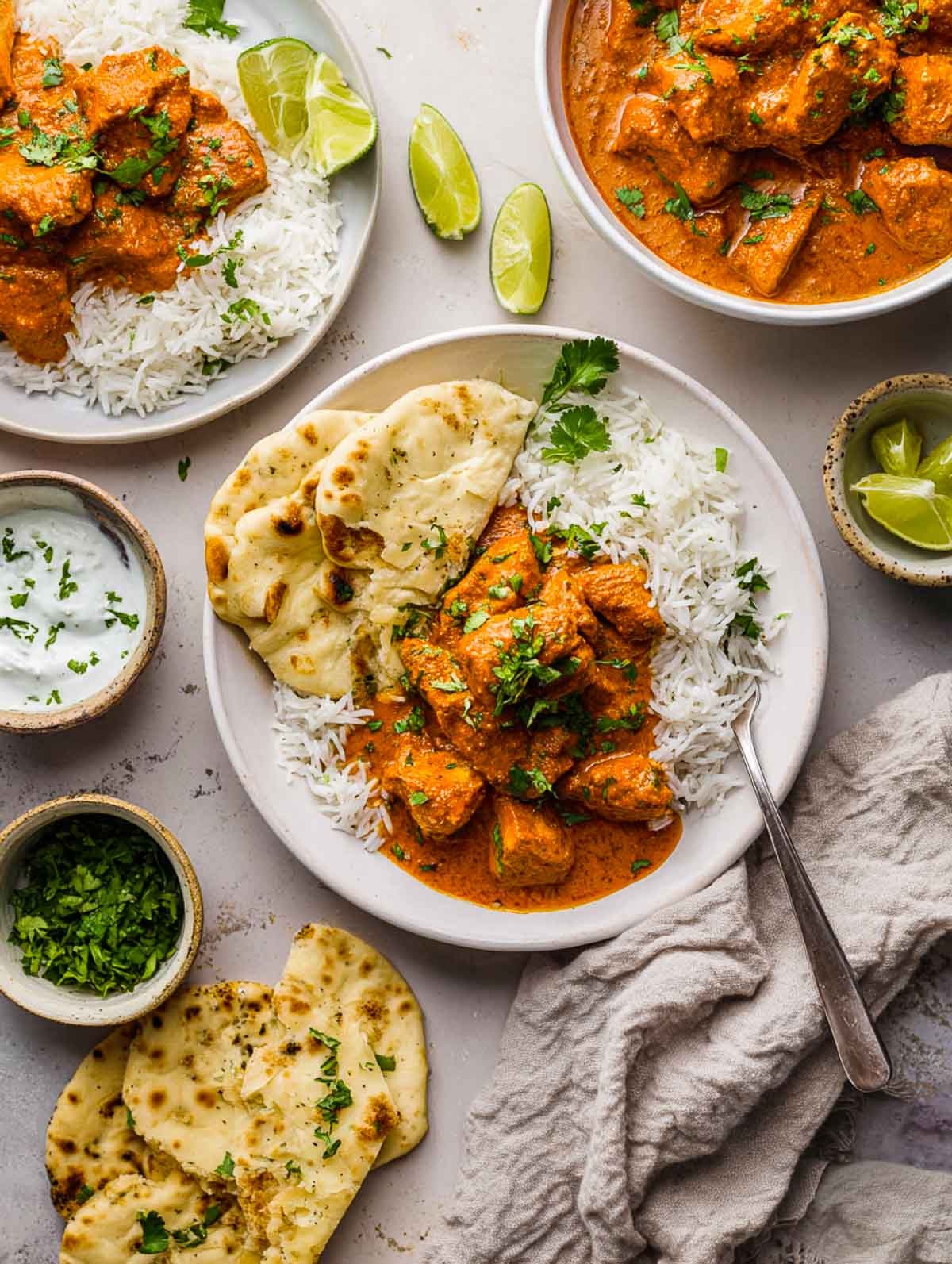 overhead shot of rich and creamy butter chicken served with naan bread and basmati rice