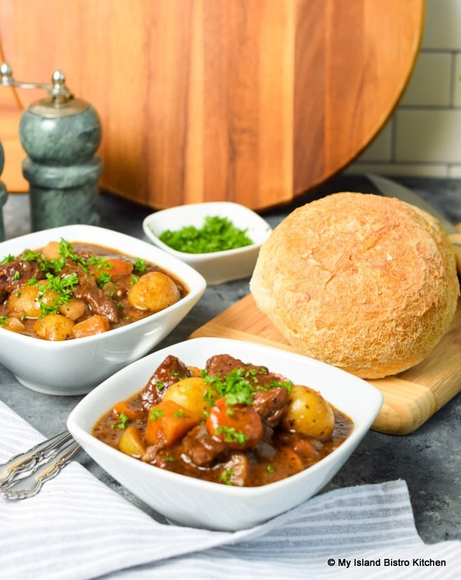 Rustic beef ground stew simmering in a Dutch oven with crusty bread and autumn vegetables