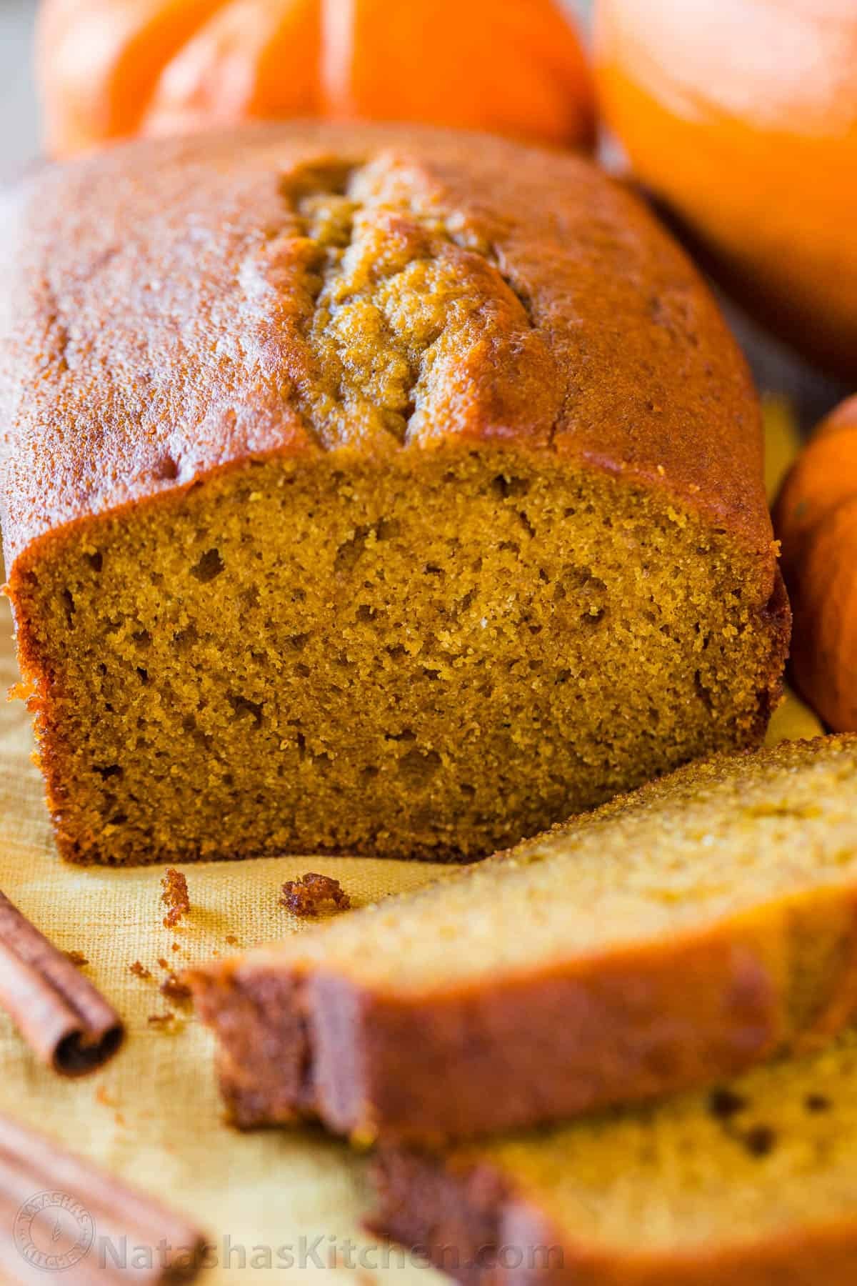 a freshly baked loaf of super moist pumpkin bread, sliced, with warm lighting