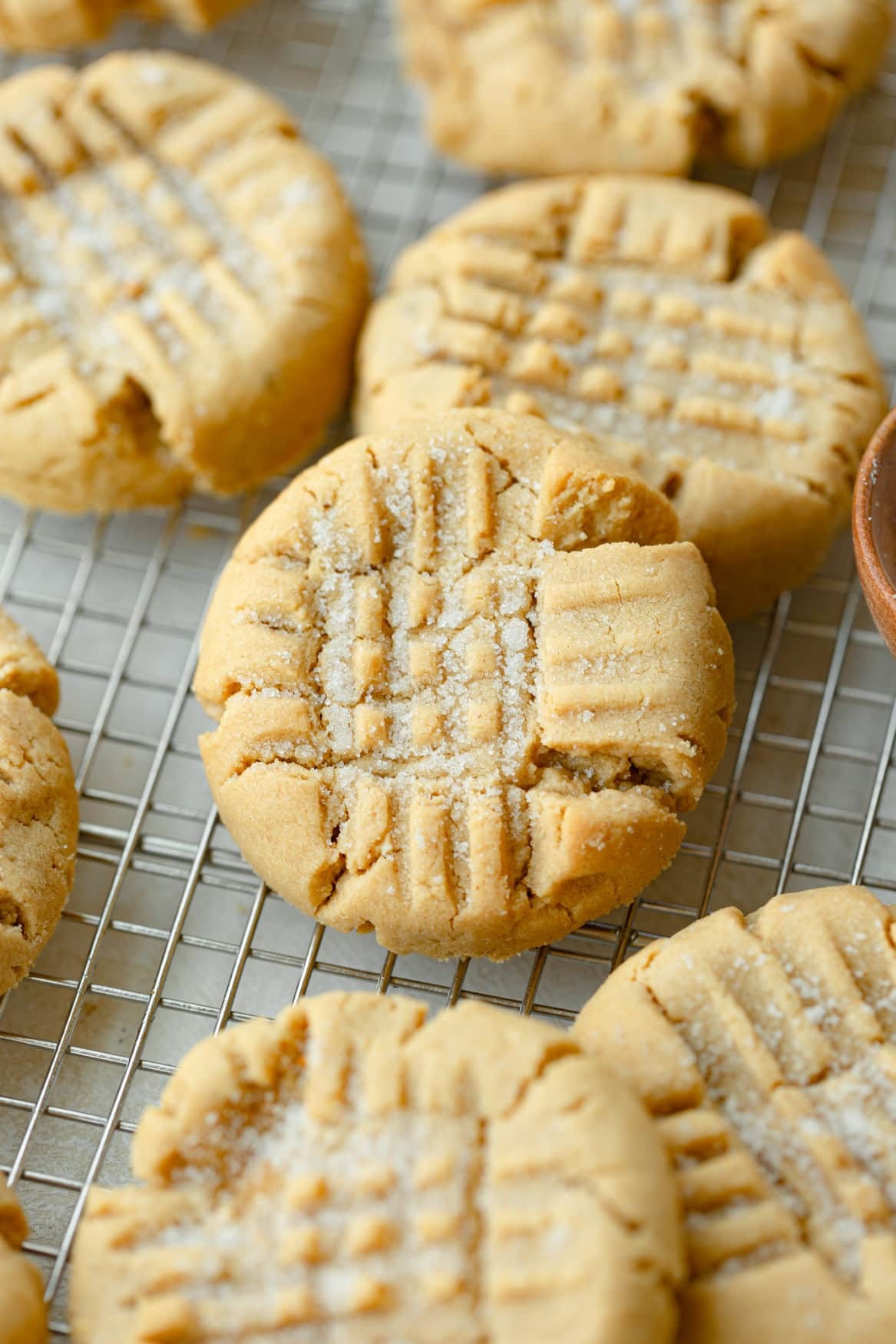 freshly baked peanut butter cookies with perfect crisscross marks cooling on a wire rack