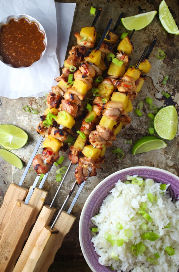 bacon and pineapple skewers being grilled with sweet chili sauce drizzled on top