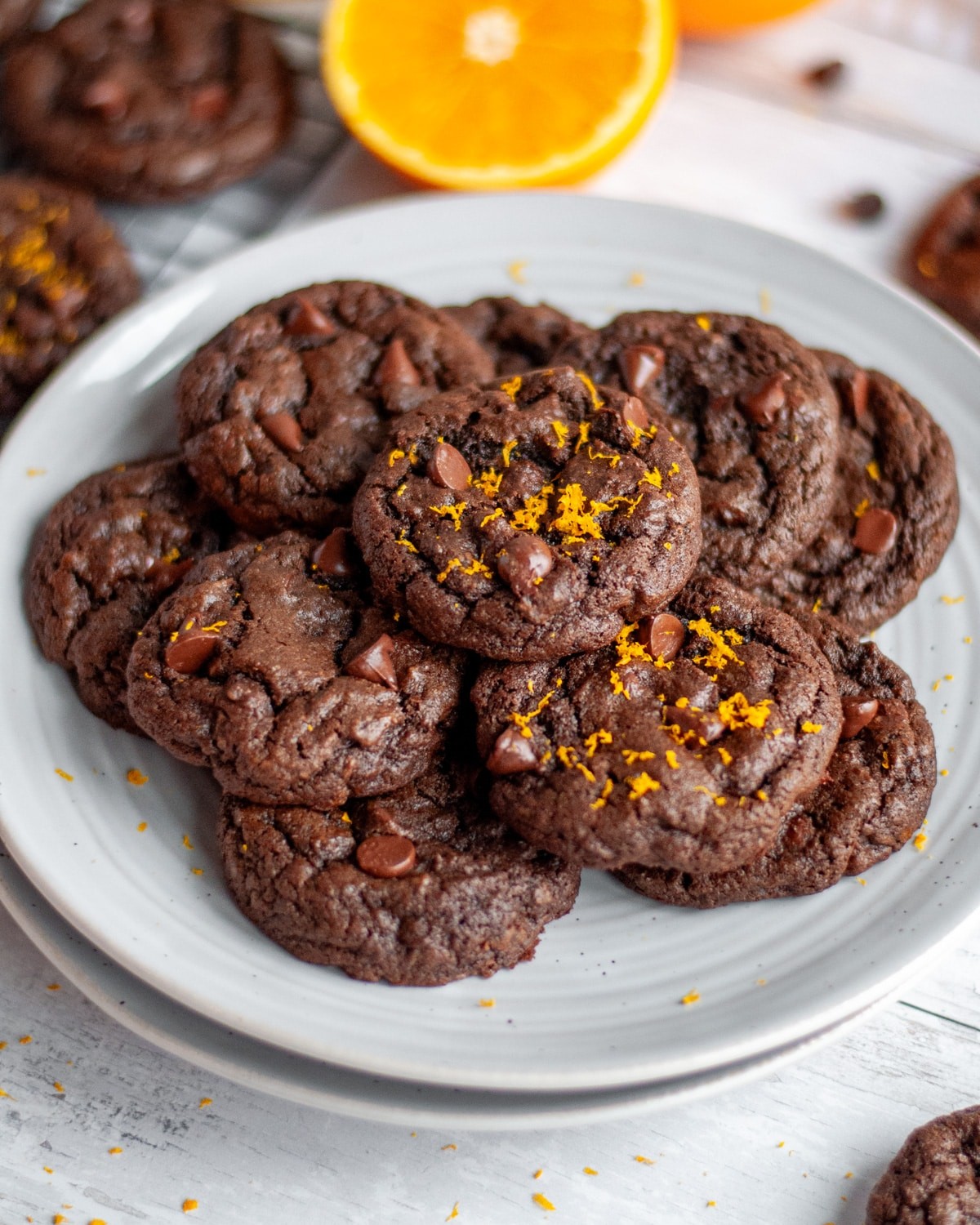 Vibrant glossy chocolate orange cookies stacked on a vintage plate, sunlight streaming
