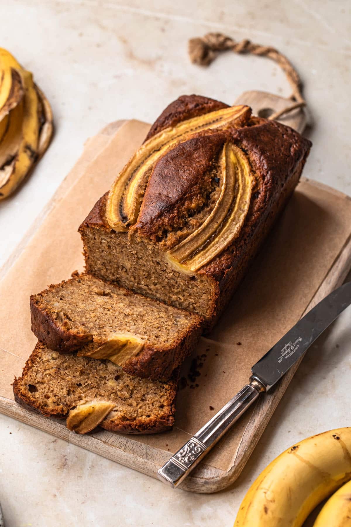 gluten-free banana bread loaf sliced on a wooden board