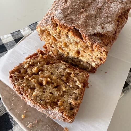 warm oatmeal banana bread with soft slices on a wooden cutting board, cozy kitchen setting