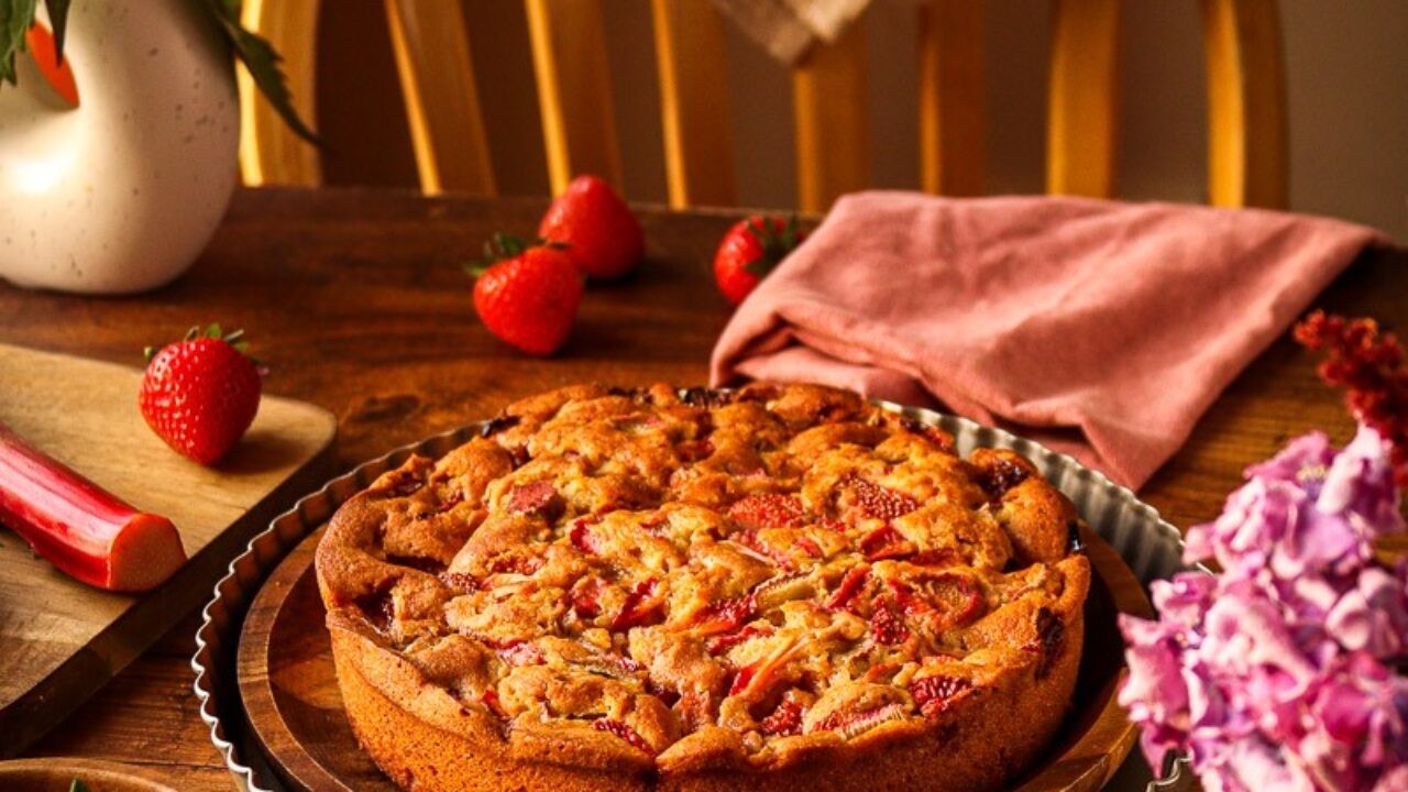 raspberry rhubarb cake on a rustic wooden table