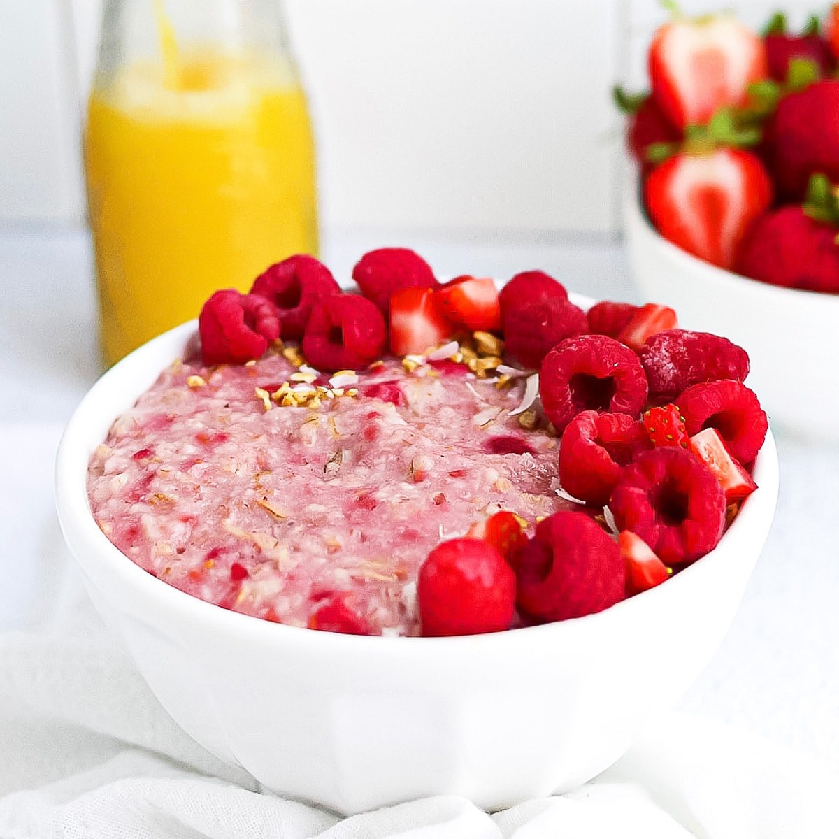 bowl of raspberry oat porridge with fresh raspberries