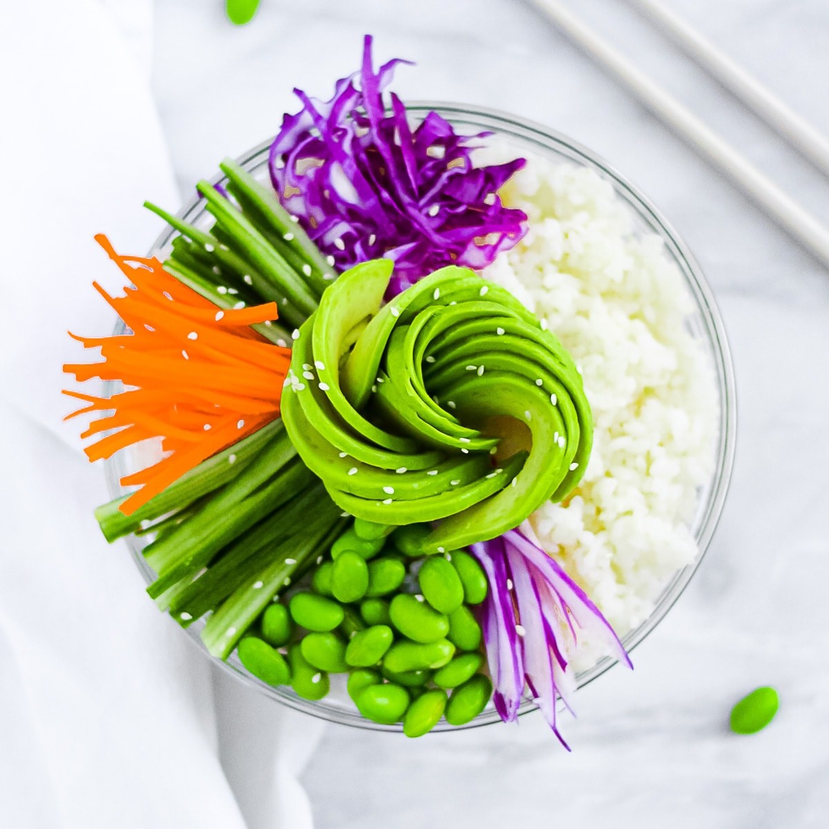 overhead shot of a rainbow veggie sushi bowl with chopsticks