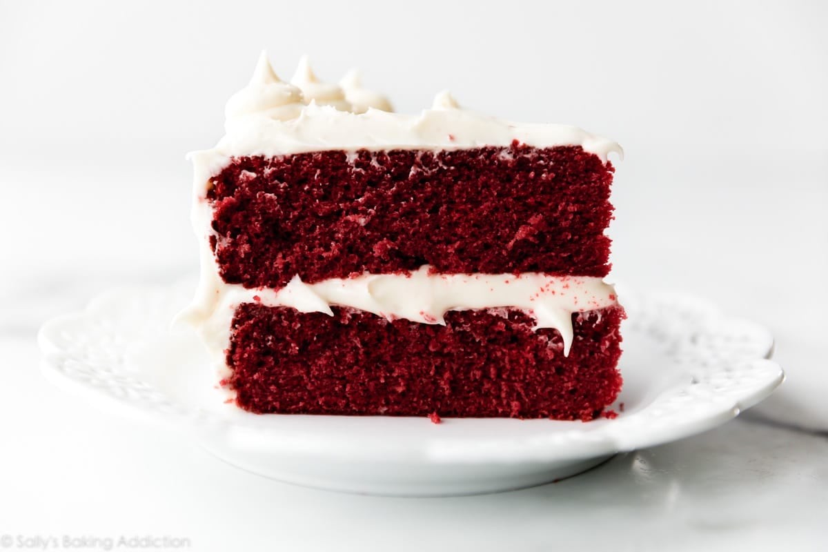 a slice of crimson velvet cake with cream cheese frosting