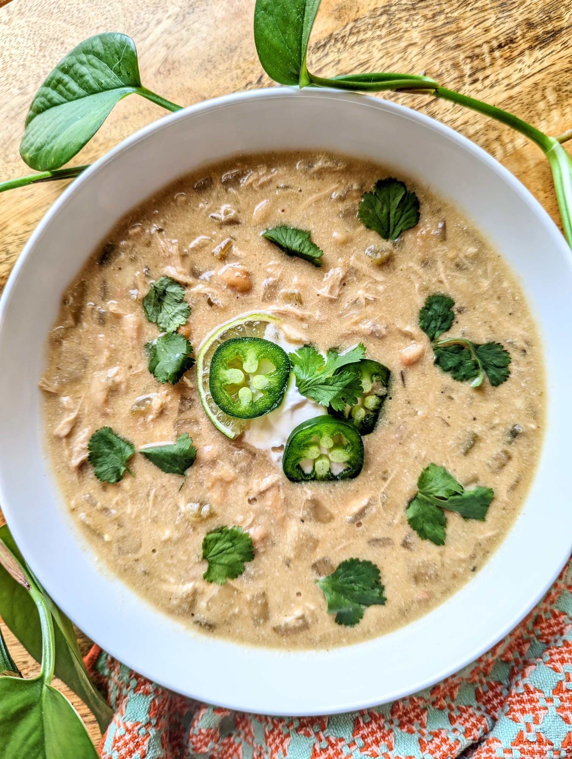 bowl of creamy white chicken chili garnished with cilantro and lime wedges