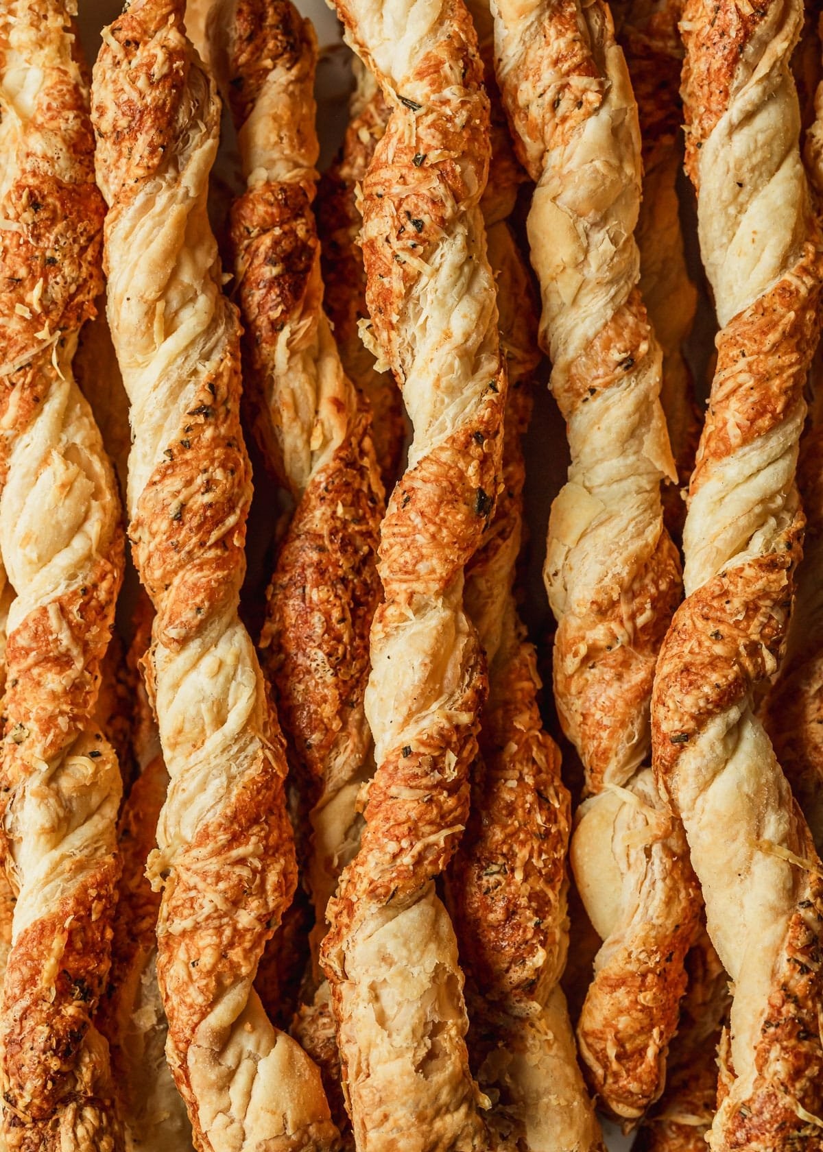 Savory Parmesan puff pastry twists close up on a baking sheet
