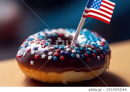 Red, white, and blue mini donuts on a serving platter, with an American flag in the background.