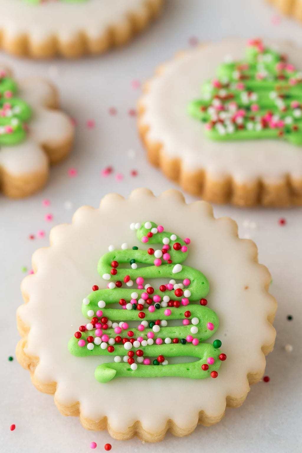 Beautifully decorated shortbread cookies with intricate icing designs on a rustic wooden table, natural light