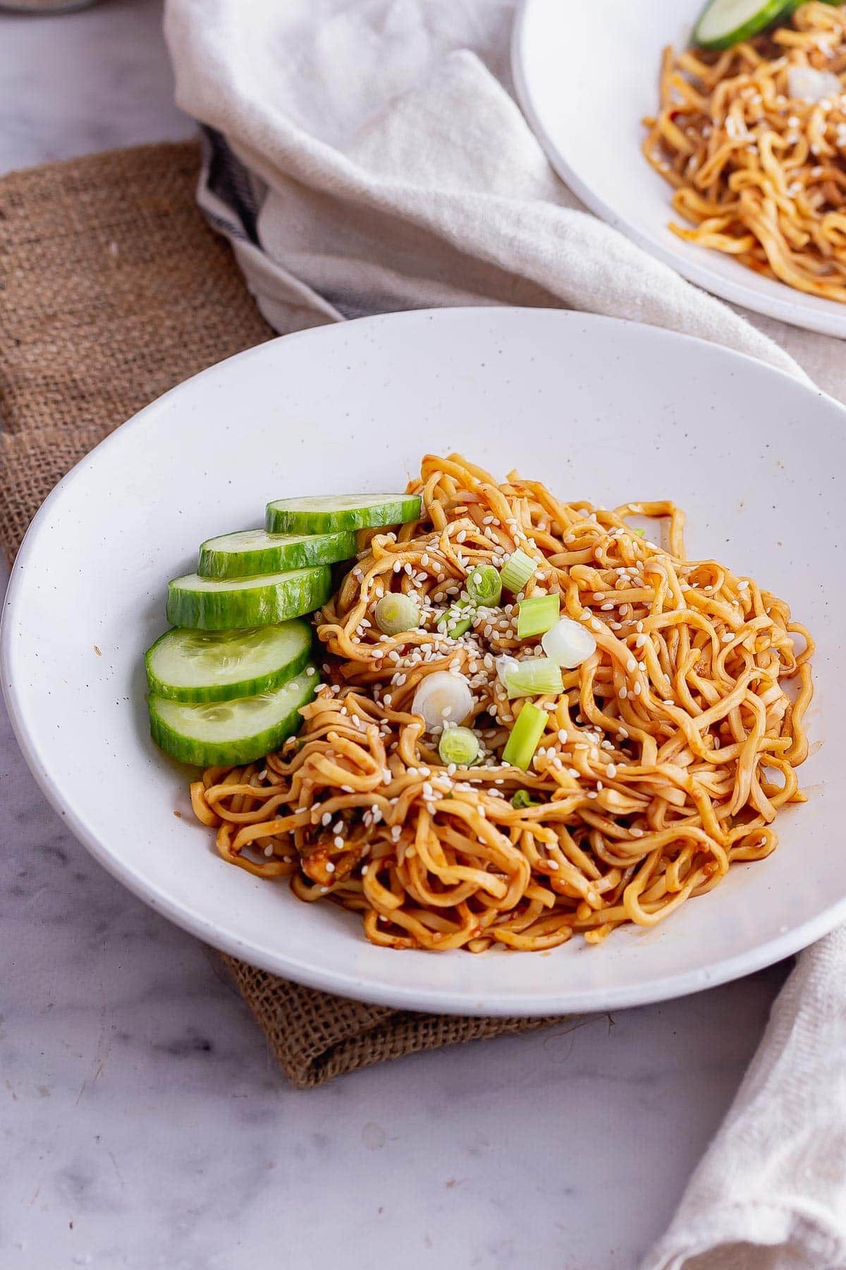 Cold peanut noodles with shredded carrots and cucumber in a bowl