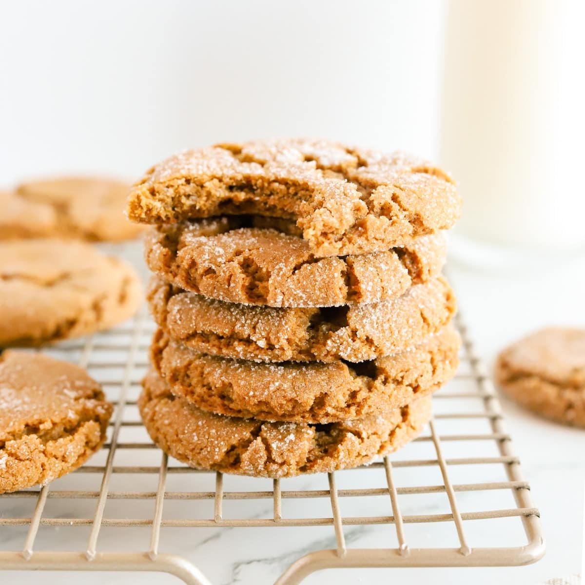 warm molasses cookies with crinkled tops on a cooling rack, cozy kitchen background