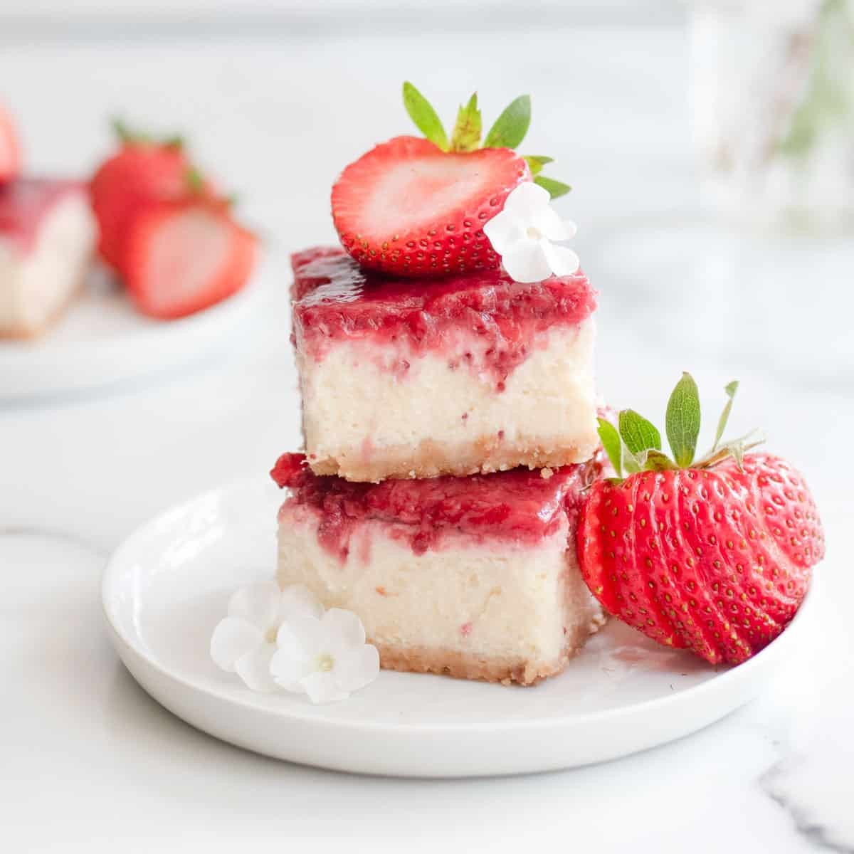 Strawberry cheesecake bars on a white plate