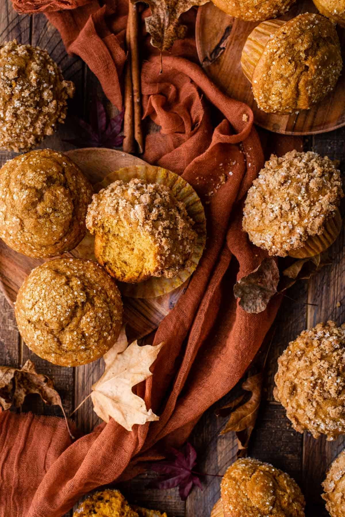 freshly baked pumpkin muffins on a wooden table with autumn leaves