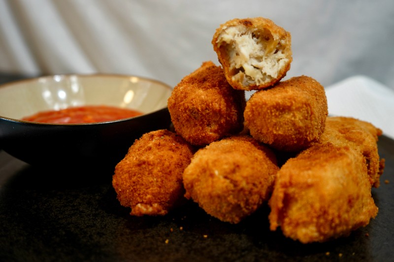 close up of golden brown chicken parmesan croquettes on a platter