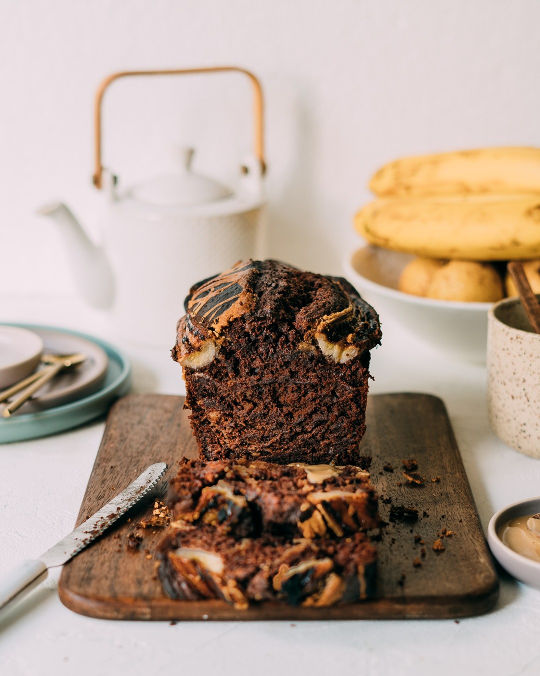 sliced banana bread with dark chocolate swirls on a cooling rack, rustic kitchen background