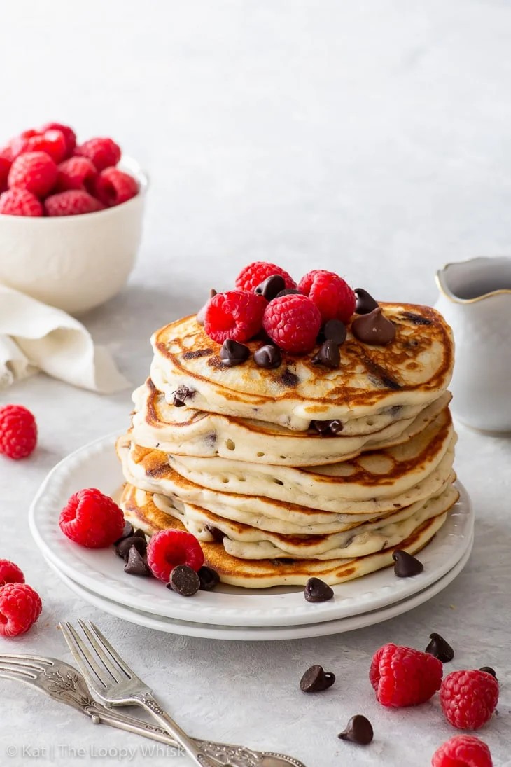 stack of chocolate chip gluten-free pancakes topped with syrup and berries