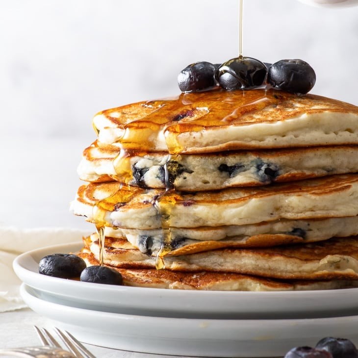 stack of gluten-free berry pancakes with syrup