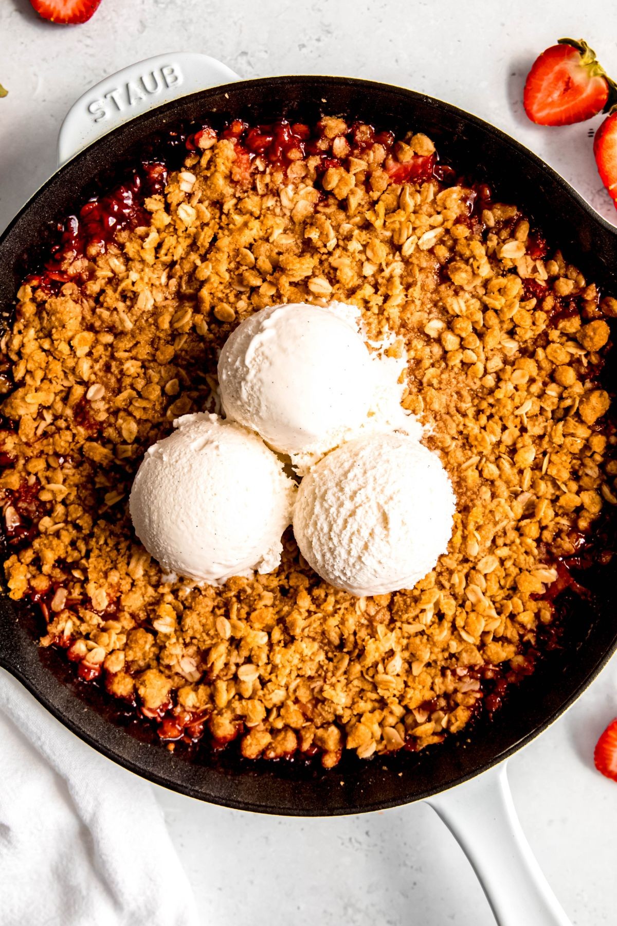 overhead shot of a homemade rhubarb crumble with a scoop of vanilla ice cream